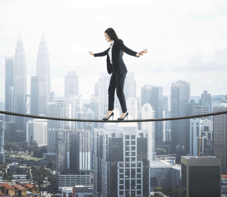 Photo of Woman Photo of Woman, dressed in business attire, walking on a high wire, above a city scape